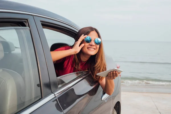Mujer asiática sonriendo con el espejo en el coche . —  Fotos de Stock