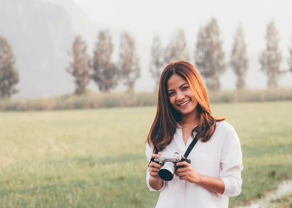 Vacker asiatisk kvinna hålla vintage kamera i hand och standin — Stockfoto