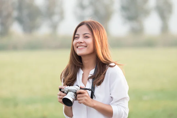 Mulher asiática bonita segurando câmera vintage na mão e standin — Fotografia de Stock