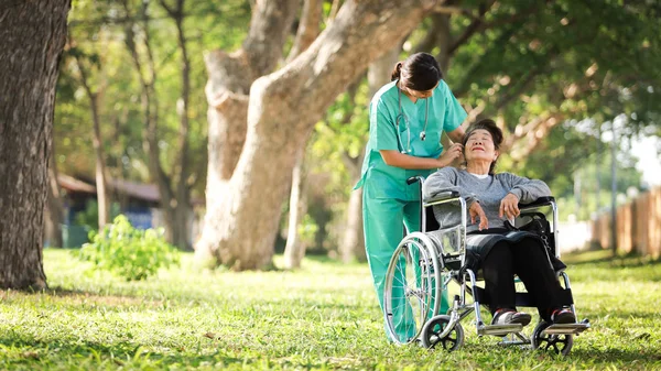 Asiática senior mujer sentado en la silla de ruedas con mujer en doct — Foto de Stock
