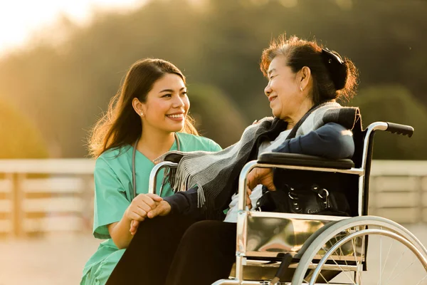 Asian senior woman sitting on the wheelchair  with woman in doct