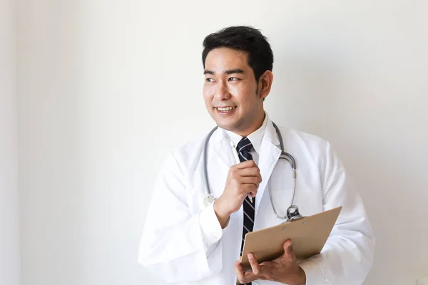 Asiático hombre en doctor uniforme en blanco fondo en hospital Imágenes De Stock Sin Royalties Gratis