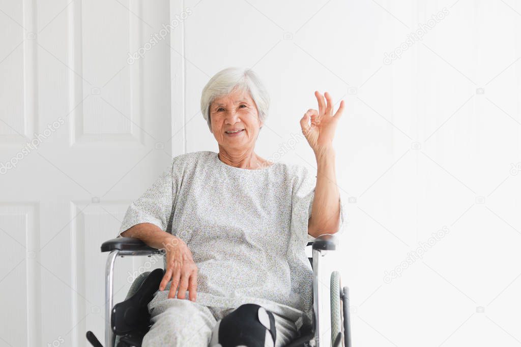 Asian old patient woman on wheelchair sickness feeling happy and smile  in hospital