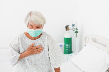Asyalı doktor hastane kliniğinde Asyalı yaşlı kadını kontrol ediyor.