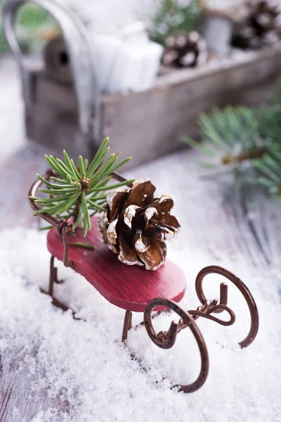 Composición navideña con trineo, piña y decoración — Foto de Stock