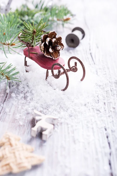 Composición navideña con trineo, piña y decoración — Foto de Stock