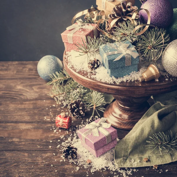 Geschenken met Kerstdecoratie op houten taart staan — Stockfoto