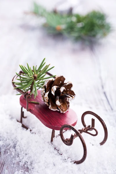 Kerstmis compositie bij slee, pinecone en decoratie — Stockfoto