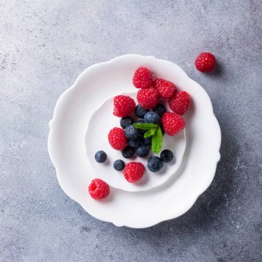 Taze yaban mersini ve ahududu beyaz tabakta aldı