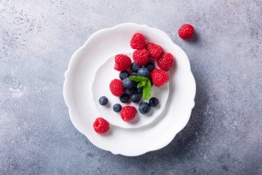 Taze yaban mersini ve ahududu beyaz tabakta aldı