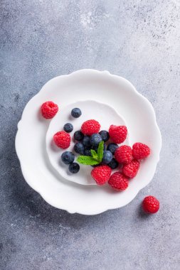 Taze yaban mersini ve ahududu beyaz tabakta aldı