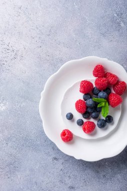 Taze yaban mersini ve ahududu beyaz tabakta aldı