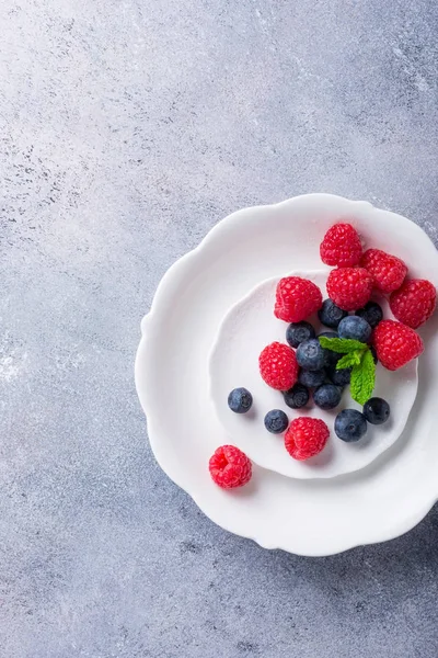 Taze yaban mersini ve ahududu beyaz tabakta aldı