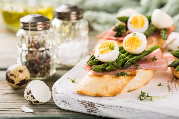 Свежий сендвич с ветчиной, спаржей и перепелиными яйцами — стоковое фото