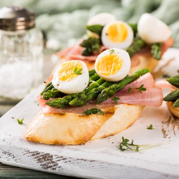 Fresh sendwich with ham, asparagus and quail eggs — Stock Photo, Image