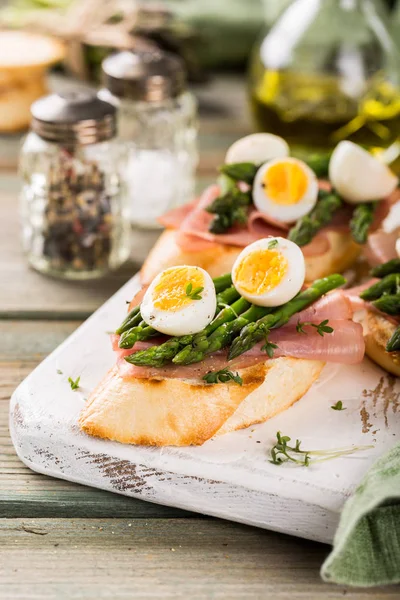 Fresh sendwich with ham, asparagus and quail eggs — Stock Photo, Image
