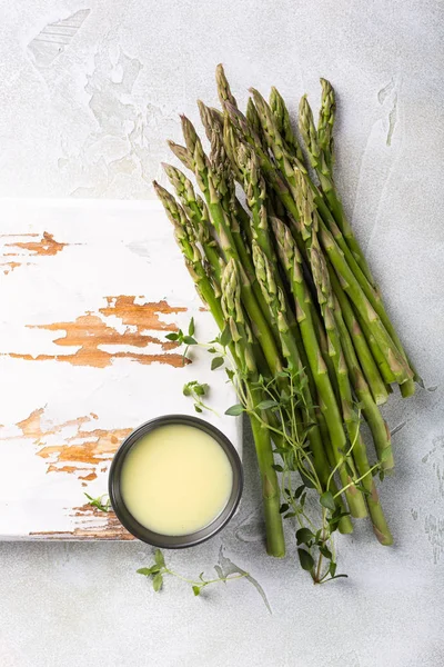 Fresh green asparagus and old white wooden board — Stock Photo, Image