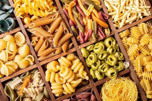 Surtido de pasta italiana colorida en caja de madera — Foto de Stock