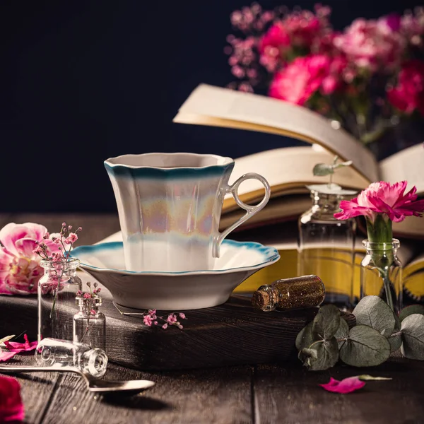 Kopp kaffe, gamla böcker och rosa nejlikor — Stockfoto