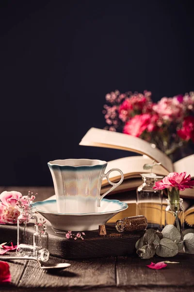 Filiżanka kawy, stare książki i różowe kwiaty goździków — Zdjęcie stockowe