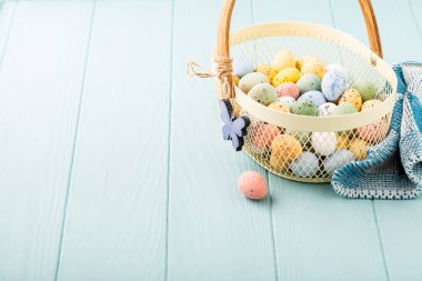 Renkli Paskalya bıldırcın yumurtası ile metal sepet
