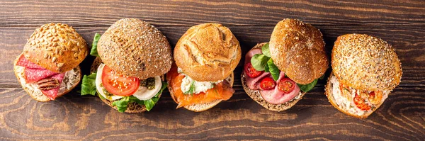 Ассорти сэндвичей на деревянном столе — стоковое фото