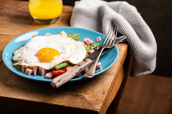 Śniadanie lub obiad z jajkiem smażonym, tostem chlebowym, zielonymi szparagami, pomidorami i bekonem — Zdjęcie stockowe