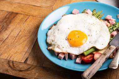 Kahvaltı ya da kızarmış yumurta, ekmek tostu, yeşil kuşkonmaz, domates ve pastırma.