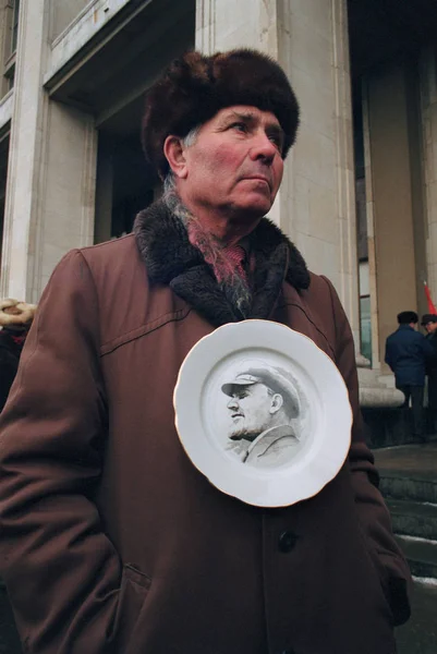 Senior man håller plattan med porträtt av Lenin — Stockfoto