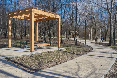 Moskova 'nın Yuzhnoye Medvedkovo İlçesi İlkbaharda parkta yaya geçidi ve ahşap pergola