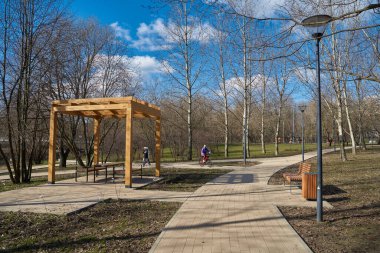 Moskova, Rusya - 22 Mart 2020: Yuzhnoye Medvedkovo İlçesi 'nde baharda parkta yaya geçidi ve ahşap pergola.