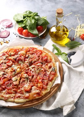 İtalyan mutfağı. Beyaz ve gri arka planda pizza. Yemek pişirme süreci. Taze sebze ve fesleğen. arkaplan resmi, kopyalama alanı, elle pizza