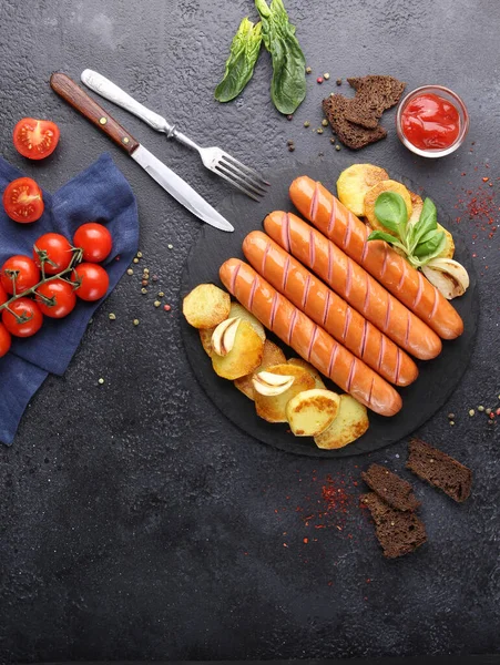 德国菜在烤架上煎的汉诺威猪肉香肠 背景是黑色的土豆 附近是番茄酱 背景图片 复制空间 — 图库照片