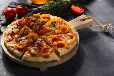 İtalyan mutfağı. Mozarellalı pizza, sarı biber, domates ve kekik gri arka planda tahta bir tahtada. Sebzeli pizza. Taşralı. Arkaplan resmi, alanı kopyala