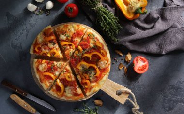 İtalyan mutfağı. Mozarellalı pizza, sarı biber, domates ve kekik gri arka planda tahta bir tahtada. Sebzeli pizza. Taşralı. Arkaplan resmi, alanı kopyala