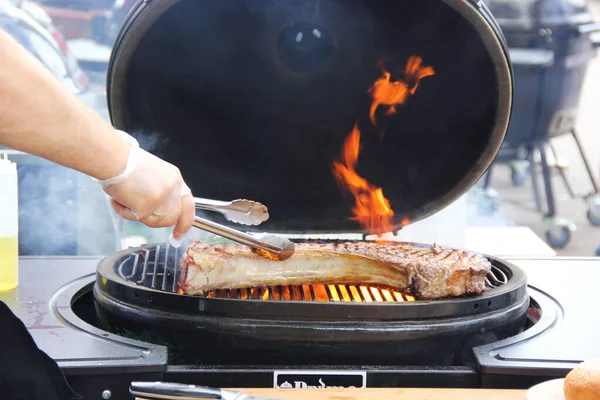 Tomahawk Stek Wołowy Ręką Grillu Dymem Ogniem Proces Gotowania Przygotowanie — Zdjęcie stockowe
