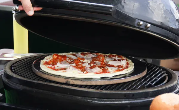 意大利菜用手在烤架上准备披萨 番茄酱 腊肠和奶酪放在木制桌子上的白板上 背景图像 复制空间 — 图库照片