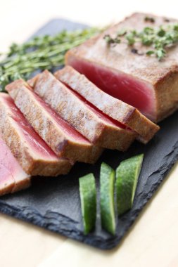 Kızarmış ton balığı, kekik ve arka planda siyah tahtada taze salatalık. Deniz ürünleri. Arkaplan resmi, alanı kopyala