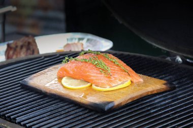 Yemek pişirme süreci. Hazırlık. Izgaradaki tahta tahtada limonlu ve kekikli somon. Arkaplan resmi, alanı kopyala