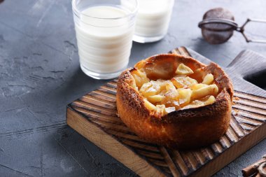 Tahtada tarçınlı elmalı turta. Bir bardak süt ve turtanın yanında elek. Arkaplan resmi, alanı kopyala