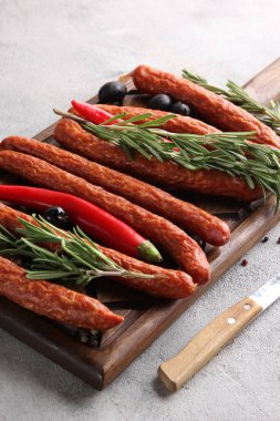 Alman mutfağı kavramı. Biberiyeli tütsülenmiş sosis, gri arka planda ahşap bir tahtada zeytin ve baharatlar. Arkaplan resmi, alanı kopyala