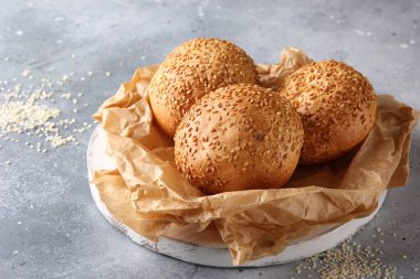 Fırın. Parşömen üzerinde susam tohumlu ekmek. Açık gri bir arkaplanda. Arkaplan resmi, alanı kopyala