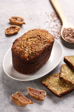 Sağlıklı yiyecekler. Açık gri arka planda incirli, fındıklı ve keten tohumlu dilimlenmiş ekmek. Arkaplan resmi, alanı kopyala