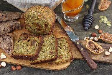 Sağlıklı yiyecekler. Tahtada incir ve tohum olan ekmek. Fındık, incir, bal, kabak tohumları ahşap bir arka planda. Taşralı. Arkaplan resmi, alanı kopyala