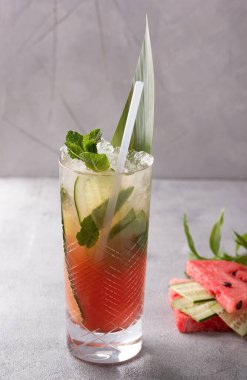İçkiler. Açık gri zemin üzerinde taze salatalık, nane ve buz bulunan bir bardakta karpuz kokteyli. Bar menüsü. Arkaplan resmi, alanı kopyala