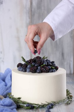 Tatlılar. Kremalı kek, jöle ve hafif ahşap arka planda el yapımı şekerlemeli taze böğürtlen. Arkaplan resmi, alanı kopyala