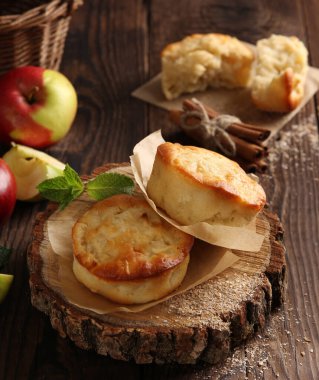 Tatlılar. Kepekli elmalı kekler, tarçın, nane, elma ve sepet ve eski ahşap arka planda. Taşralı. Arkaplan resmi, alanı kopyala