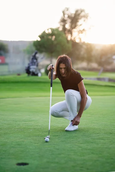 Vrouw golfer check line voor het zetten van golfbal op groen — Stockfoto