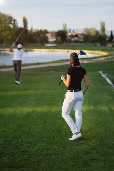 Woman golfer waiting her turn to tee of