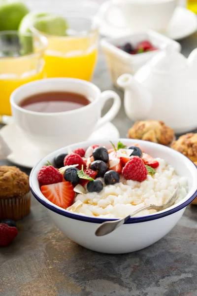 Rice pudding with fresh berries and coconut for breakfast — Stock Photo, Image